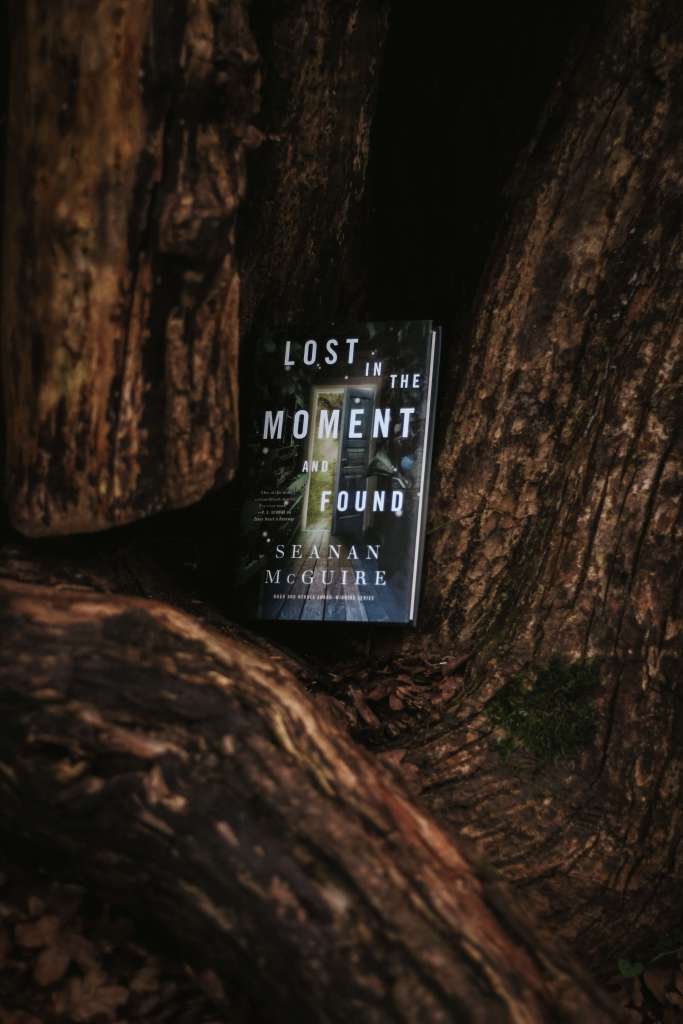 Lost in the Moment and Found by Seanan McGuire sitting in an alcove of twisted trunks